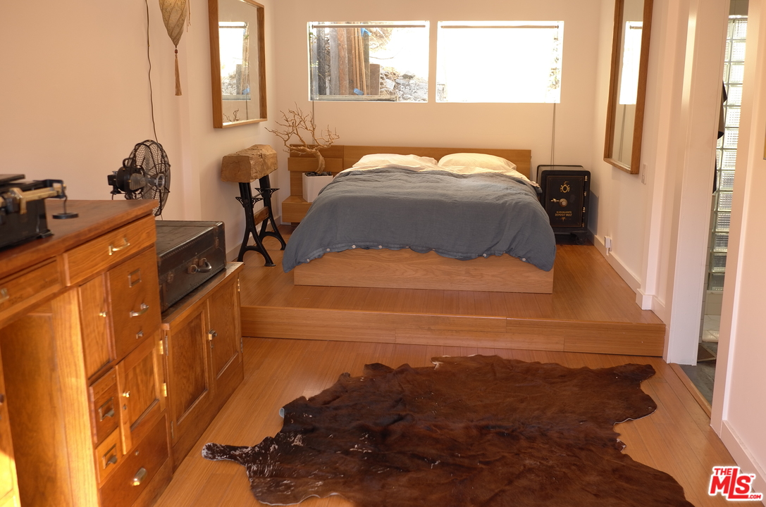 8521 Ridpath Drive Los Angeles, CA 90046 - Photo 10 of 14 a bedroom with a bed and wooden floor