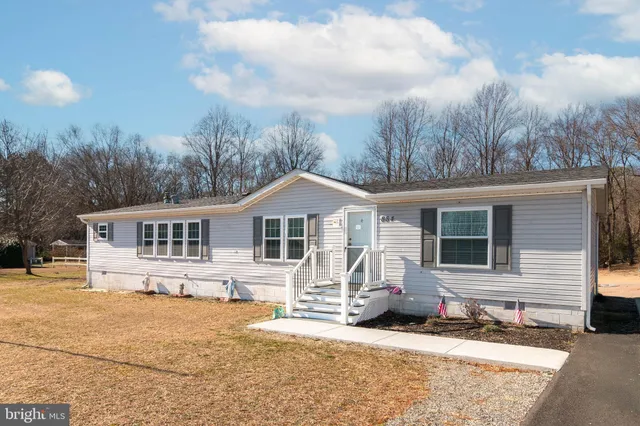 a front view of a house with a yard covered in snow