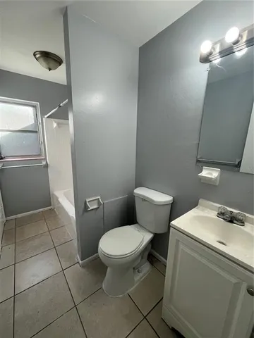 a white toilet sitting next to a bathroom sink and a mirror