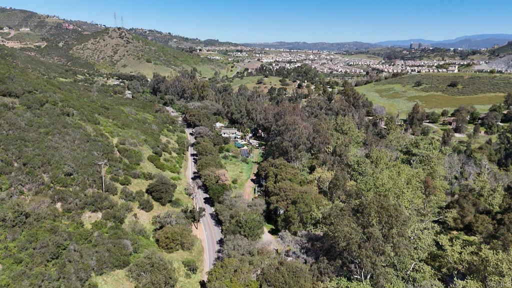 an aerial view of residential houses with outdoor space and trees