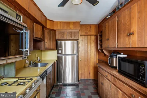 a kitchen with stainless steel appliances granite countertop a refrigerator a stove and a sink