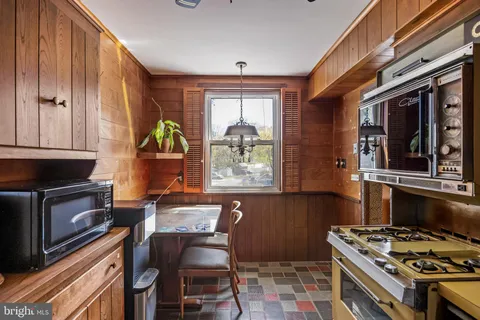 a kitchen with stainless steel appliances granite countertop a stove a sink dishwasher and cabinets with wooden floor