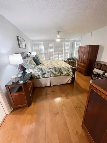 a bedroom with a bed large mirror and dresser