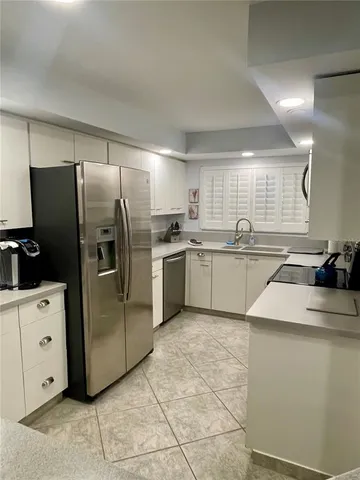 a kitchen with a refrigerator sink and cabinets