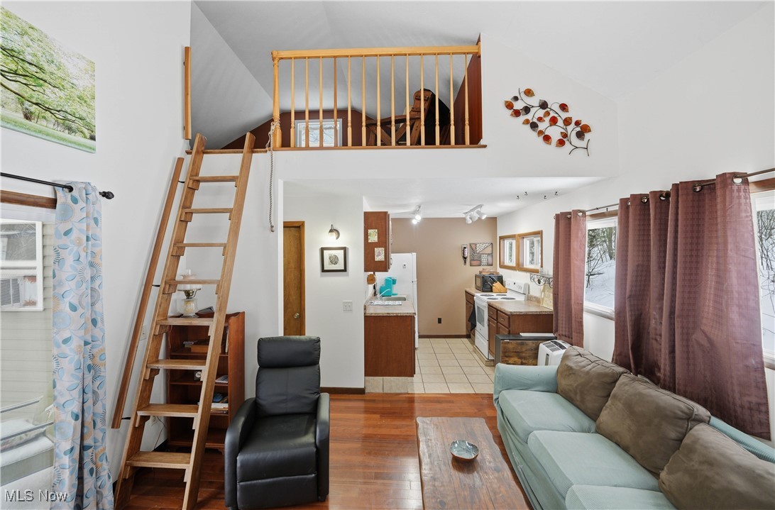4254 Doral Road Southwest Carrollton, OH 44615 - Photo 22 of 46 Living room with light wood-type flooring and high vaulted ceiling