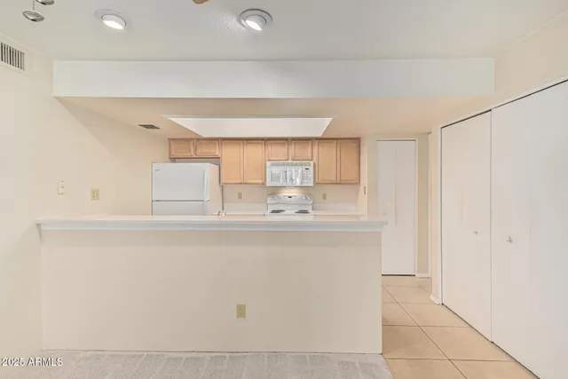 a kitchen with white cabinets and white appliances