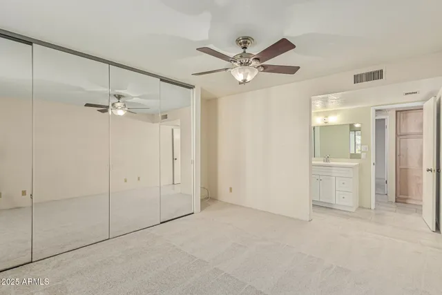 an empty room with a ceiling fan and a window