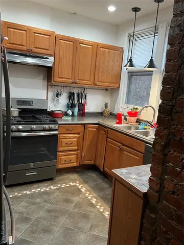 a kitchen with stainless steel appliances granite countertop a stove a sink and a refrigerator