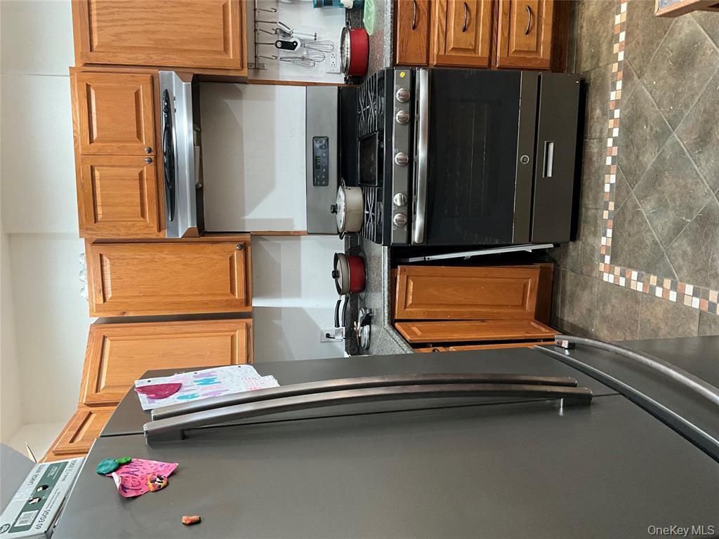 265 Spring Street Monroe, NY 10950 - Photo 3 of 20 a kitchen with granite countertop a stove and cabinets