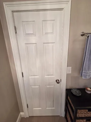 a bedroom with a bed and a lamp on dresser