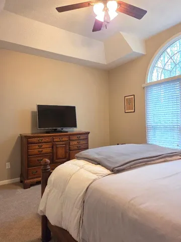 a bathroom with a granite countertop toilet sink and mirror