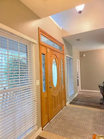 a living room with furniture wooden floor and glass windows