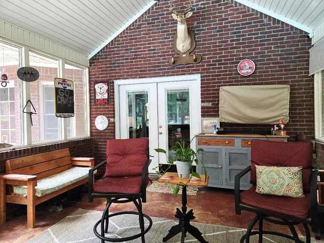 a view of a backyard with potted plants and large trees