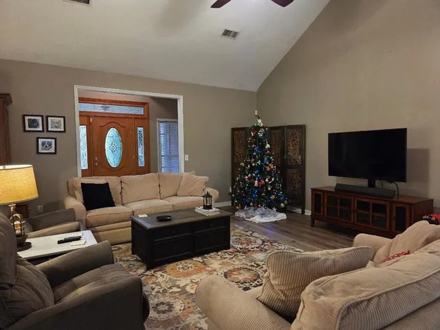 a living room with furniture a flat screen tv and a fireplace