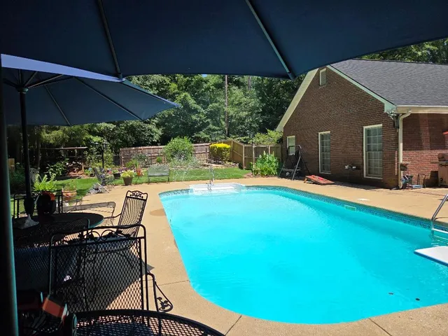 a view of a house with large trees in the background