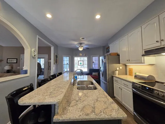 a kitchen with a sink a stove a dining table and chairs