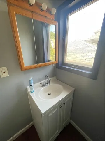 a bathroom with a sink a mirror and a window
