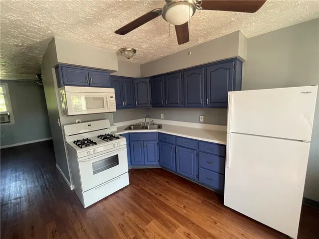a kitchen with wooden cabinets and white appliances
