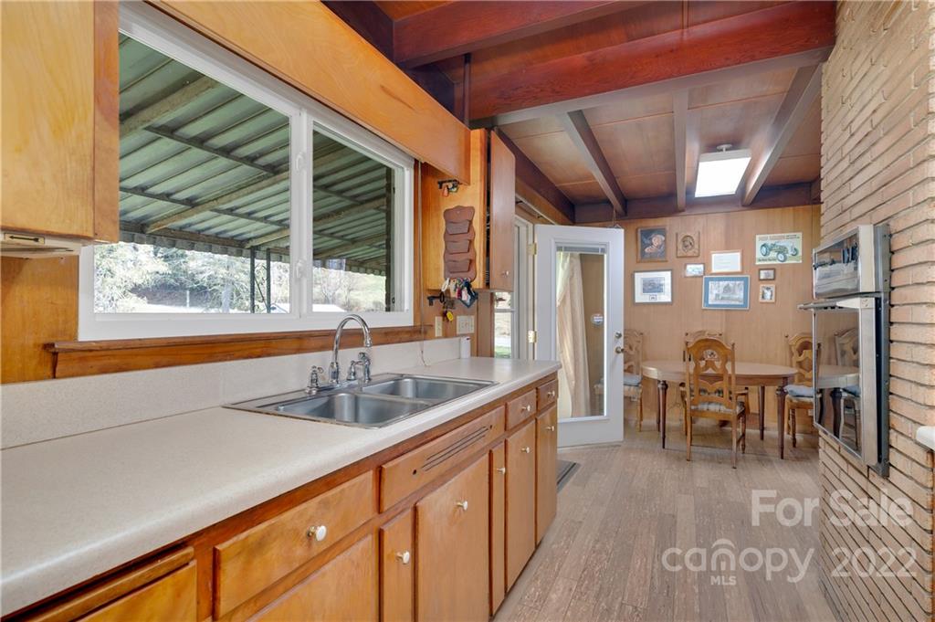 1715 Thickety Road Clyde, NC 28721 - Photo 12 of 25 a kitchen with stainless steel appliances granite countertop a sink and wooden floors