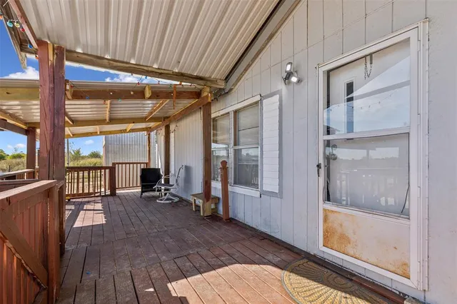 a view of a balcony with chairs and wooden floor