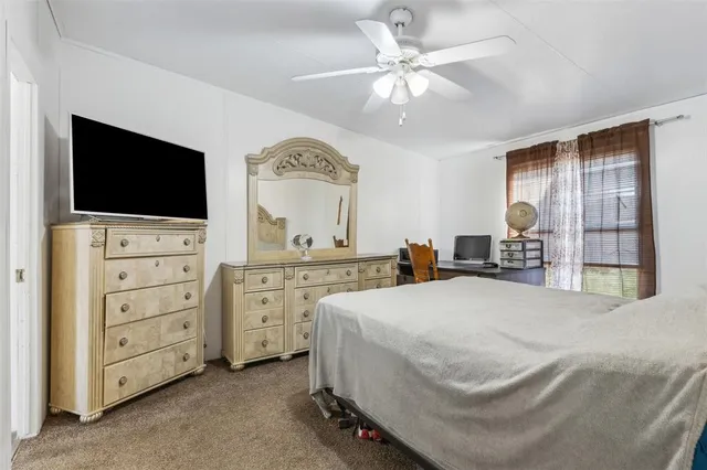a spacious bedroom with a bed and a flat screen tv