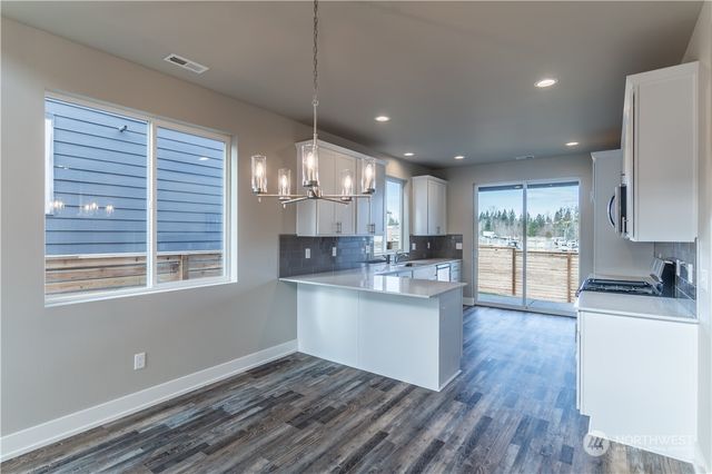 a open kitchen with kitchen island a stove a sink a center island and wooden floor
