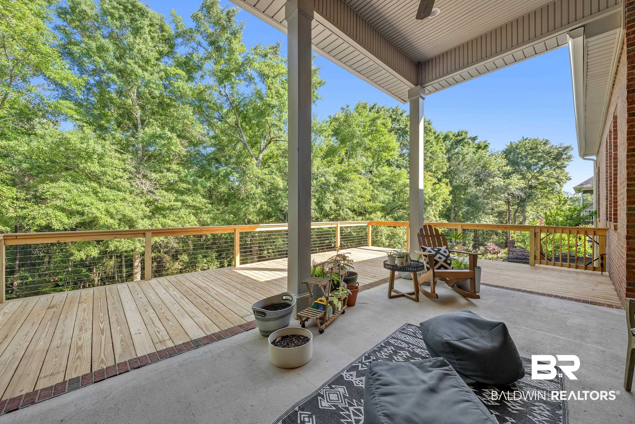 8137 Pine Run Daphne, AL 36527 - Photo 42 of 67 Expansive outdoor living area featuring a covered concrete patio, a large wood-finish deck with cable railing, an overhead ceiling fan, and a brick exterior wall