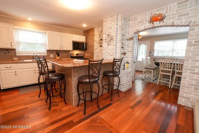 a kitchen with stainless steel appliances granite countertop a white cabinets and a refrigerator