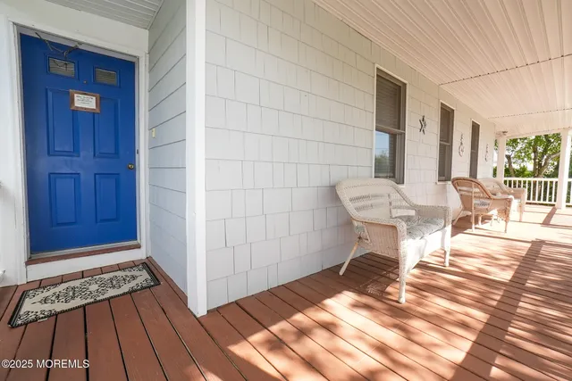 a balcony with wooden floor table and chairs