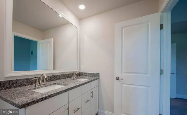 a bathroom with a granite countertop sink and a mirror