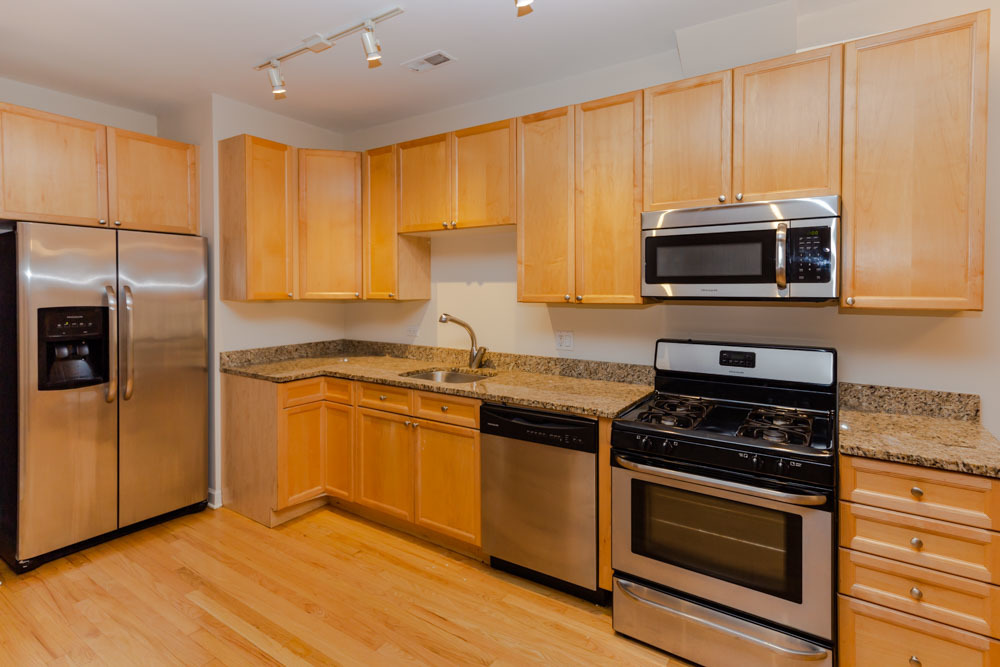 3349 North Clark Street, Unit 2SW Chicago, IL 60657 - Photo 2 of 13 a kitchen with granite countertop a stove a sink and a microwave