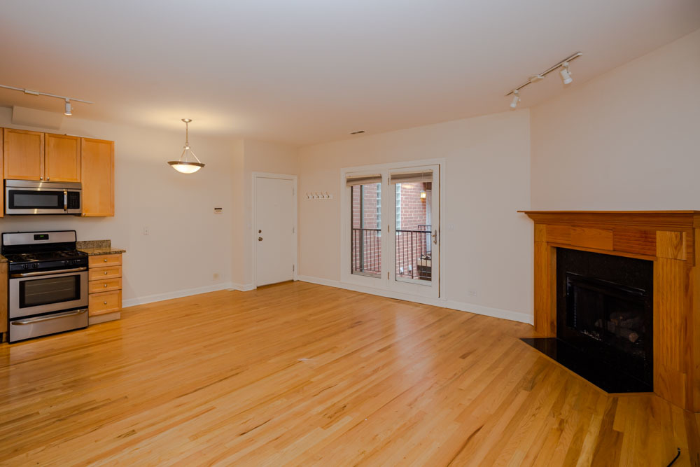 3349 North Clark Street, Unit 2SW Chicago, IL 60657 - Photo 3 of 13 a view of an empty room with a fireplace and a window
