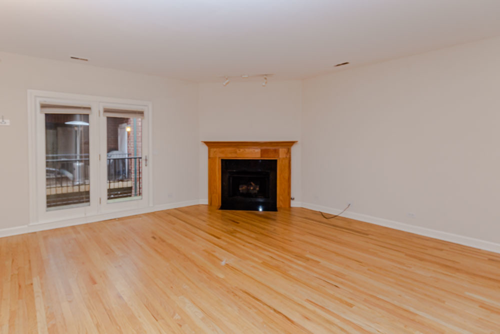 3349 North Clark Street, Unit 2SW Chicago, IL 60657 - Photo 4 of 13 a view of an empty room with wooden floor and a window