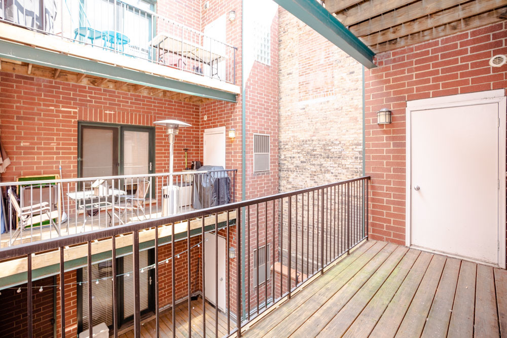 3349 North Clark Street, Unit 2SW Chicago, IL 60657 - Photo 5 of 13 a view of a balcony with wooden floor and fence