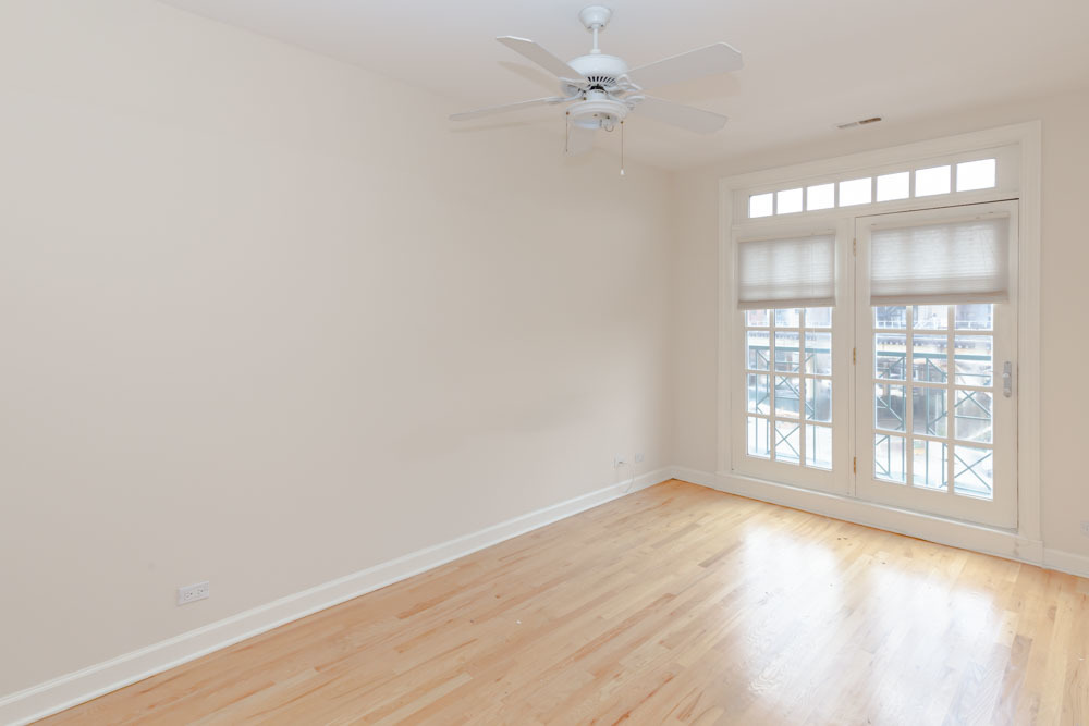 3349 North Clark Street, Unit 2SW Chicago, IL 60657 - Photo 7 of 13 an empty room with wooden floor and windows