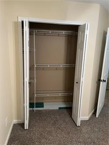an empty room with closet and a white door