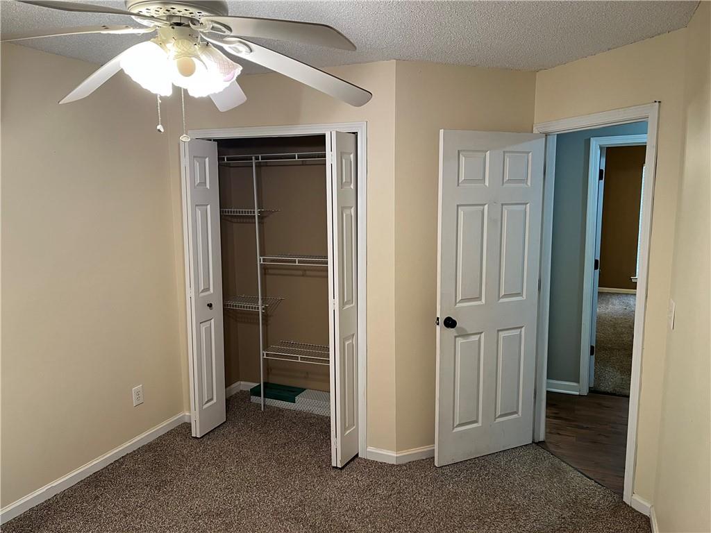 111 Green Point Way Carrollton, GA 30117 - Photo 23 of 29 an empty room with closet and a chandelier fan