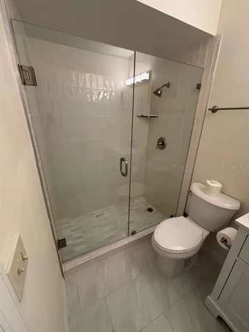a bathroom with a toilet and a shower