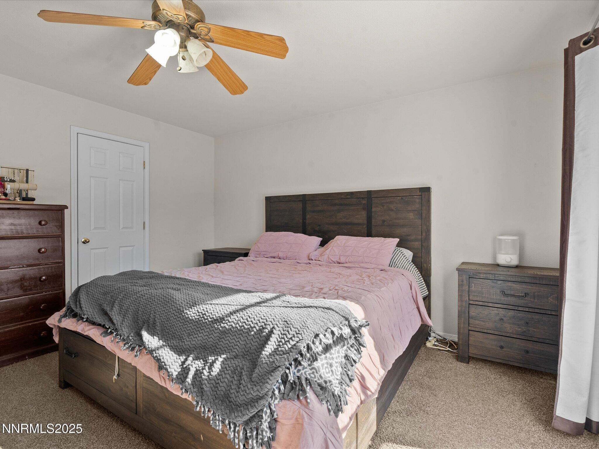 1819 Bogie Court Fernley, NV 89408 - Photo 19 of 46 a bedroom with a bed and a chandelier