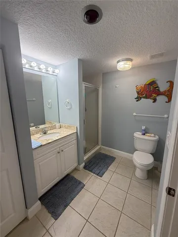 a bathroom with a granite countertop sink a toilet and a mirror