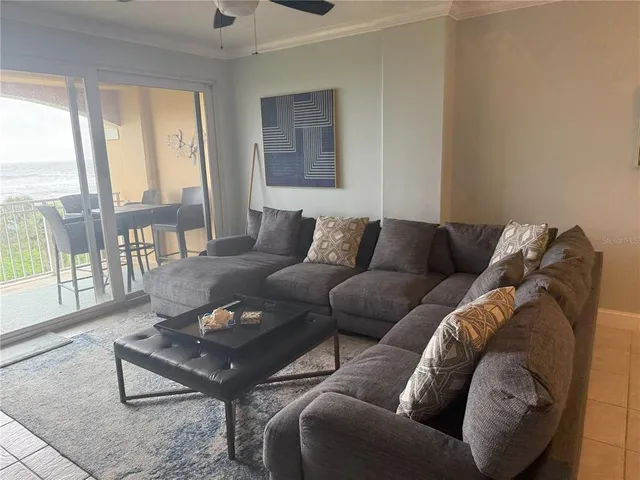 a living room with furniture and a floor to ceiling window