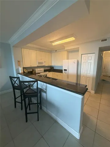 a kitchen with stainless steel appliances granite countertop a sink and a refrigerator