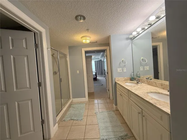 a bathroom with a granite countertop sink a mirror and a shower