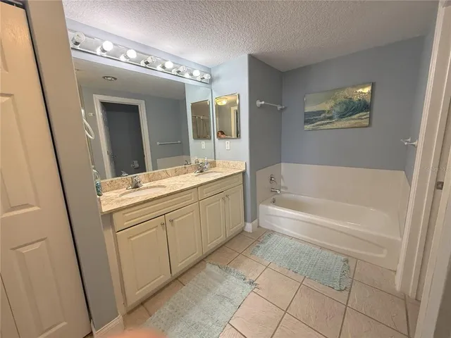 a bathroom with a tub sink and mirror