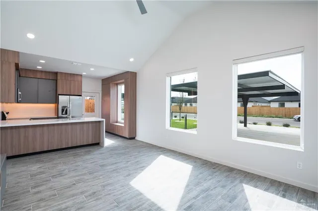 a large kitchen with a wooden floor and window