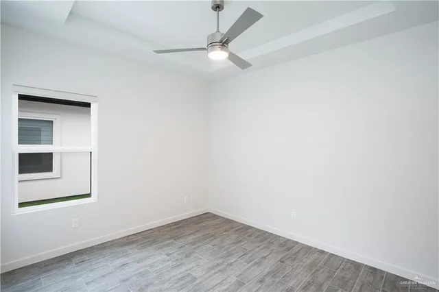 an empty room with a window and a ceiling fan