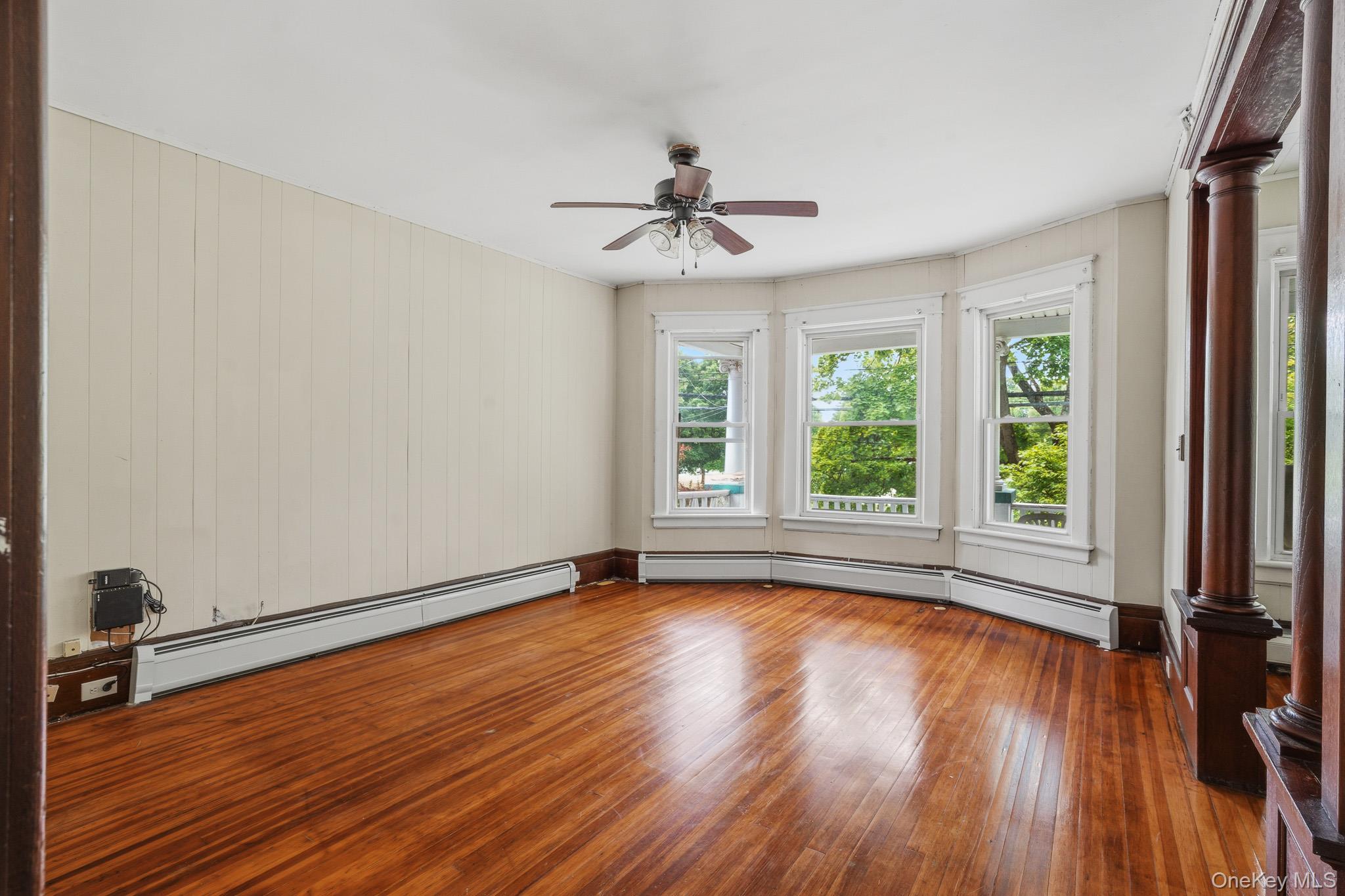 65 North Clinton Street Poughkeepsie, NY 12601 - Photo 11 of 43 an empty room with wooden floor chandelier fan and windows