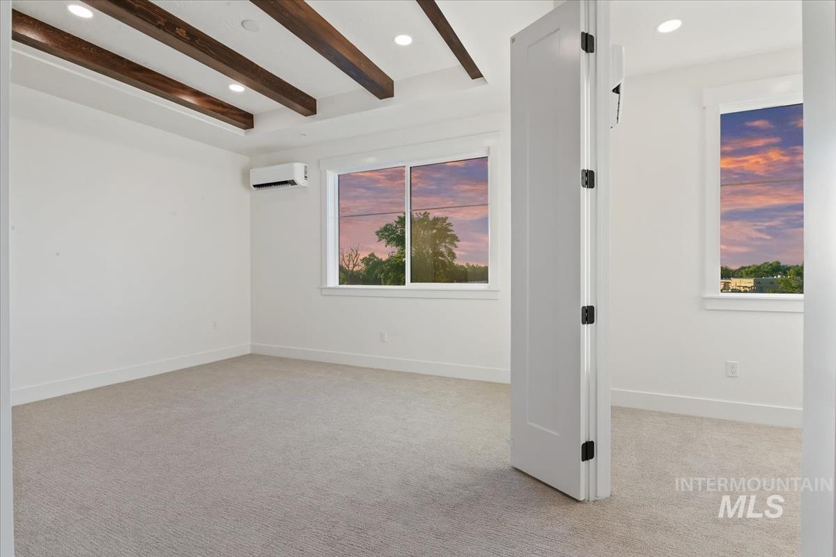 3249 West Moore Street Boise, ID 83702 - Photo 13 of 35 Empty room with beam ceiling, light colored carpet, recessed lighting, and a wall mounted AC