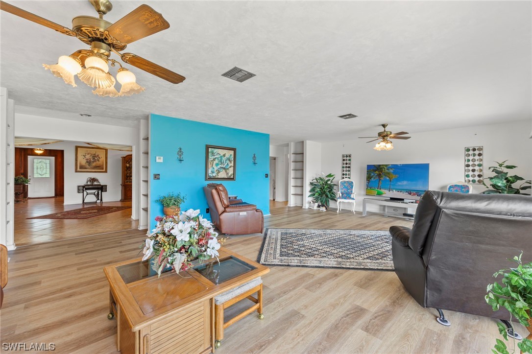 13751 River Road Fort Myers, FL 33905 - Photo 15 of 50 a living room with furniture a chandelier and a fireplace