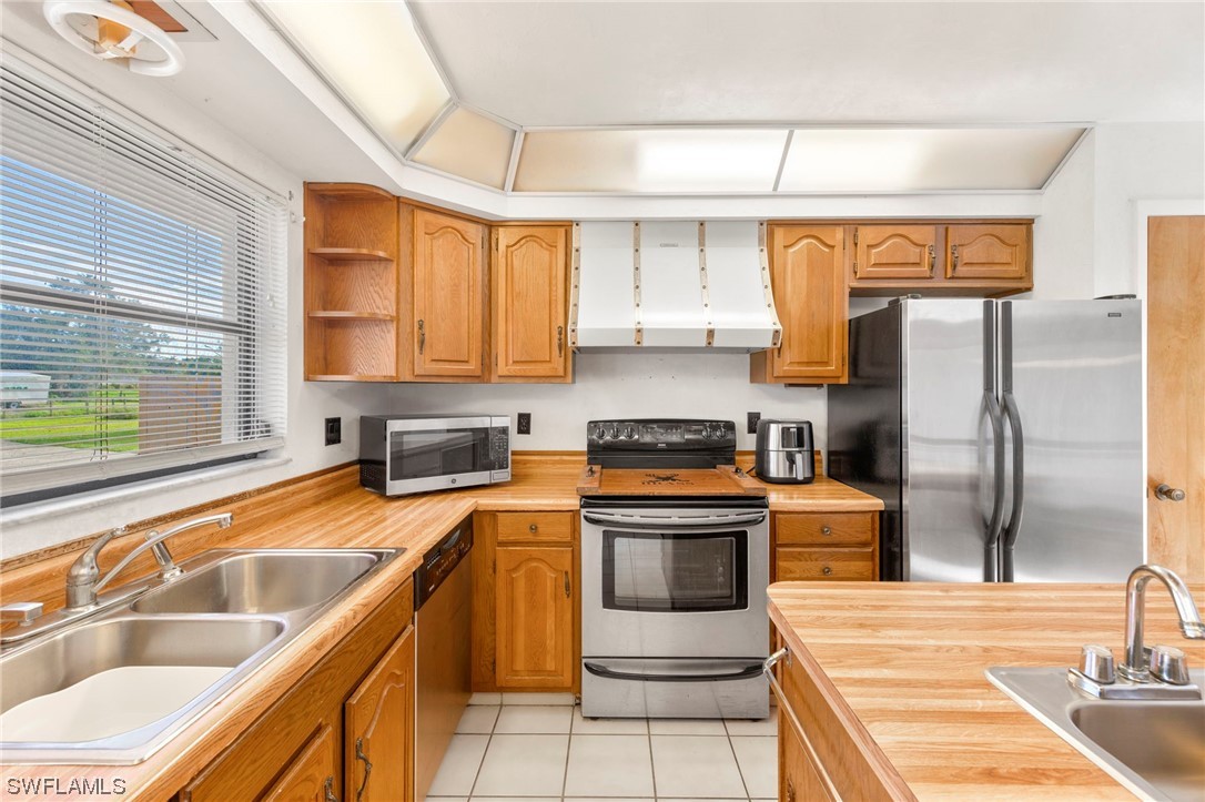 13751 River Road Fort Myers, FL 33905 - Photo 22 of 50 a kitchen with stainless steel appliances granite countertop a sink a stove and a refrigerator